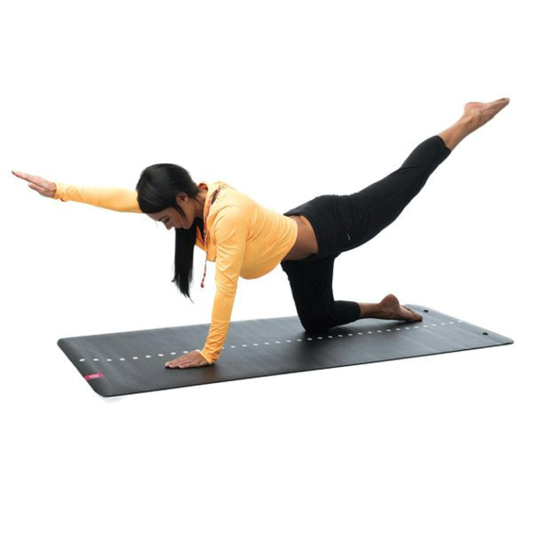 kvinna som kör pilates på en svart yogamatta