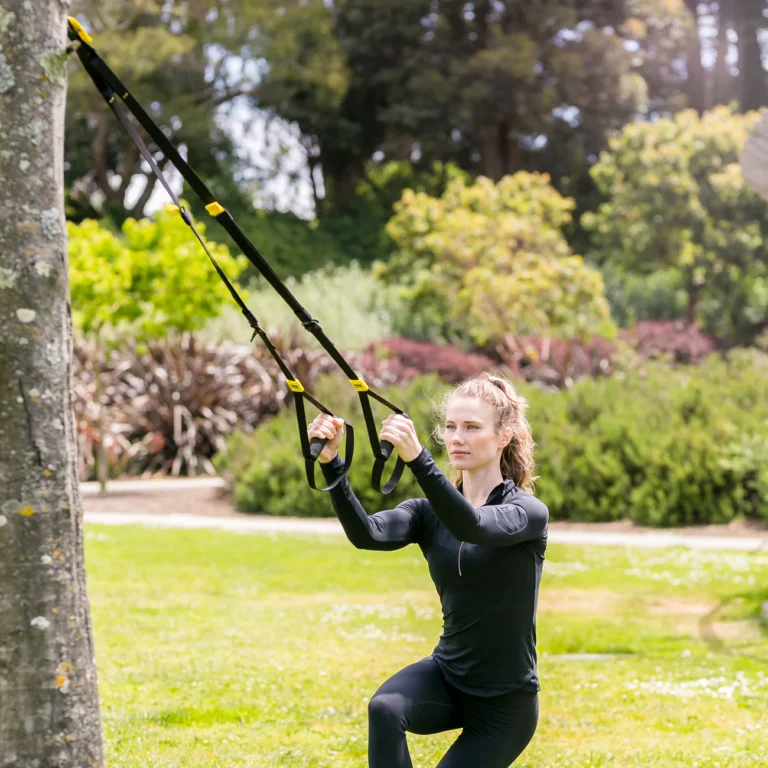 En kvinna som tränar utomhus med TRX Move
