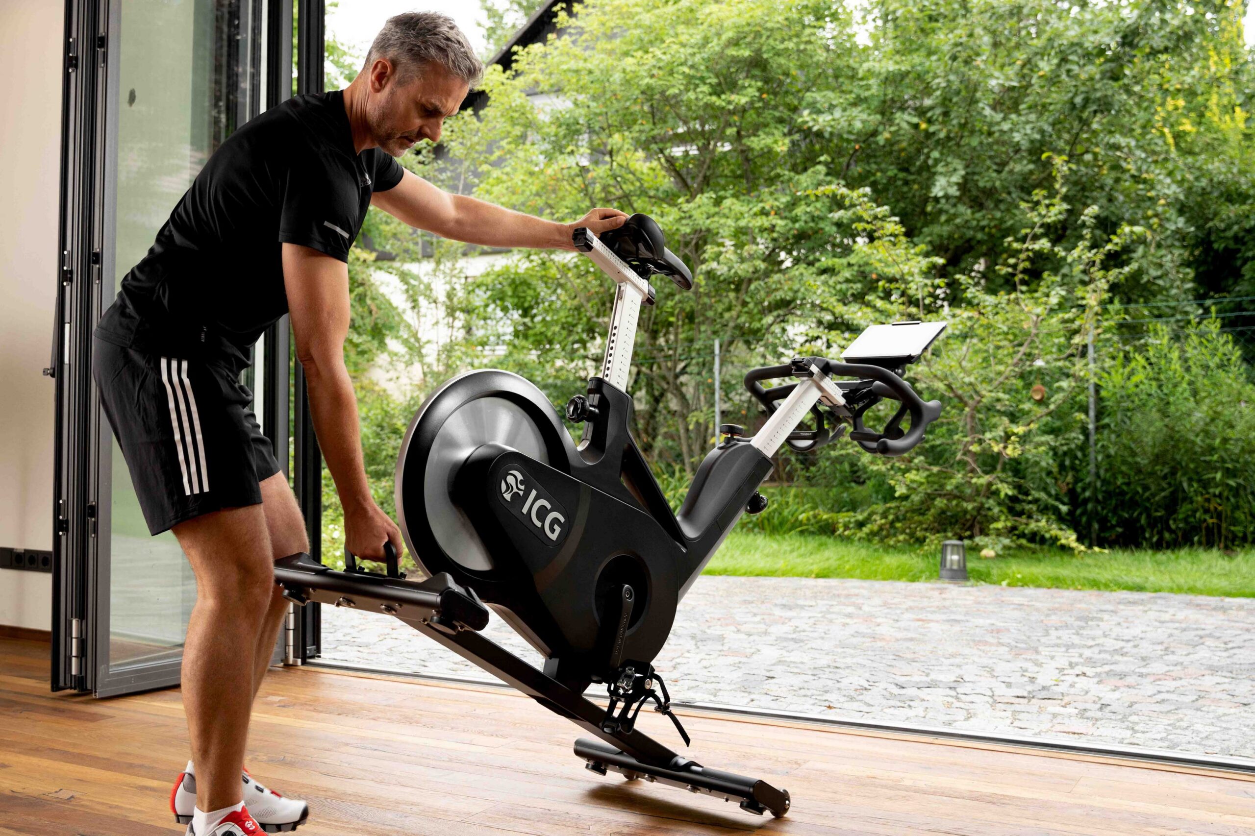 En man som flyttar ut en spinningcykel från ICG till altanen